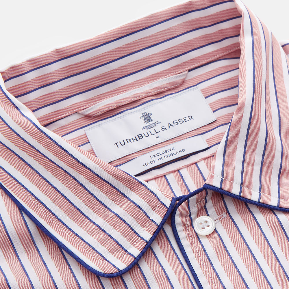 The Orange Multi Stripe Cotton Sussex Nightshirt by Turnbull & Asser features a classic collar, red and white vertical stripes, a chest pocket with blue trim, button-down front, and curved hem—a luxe take on the traditional nightshirt.