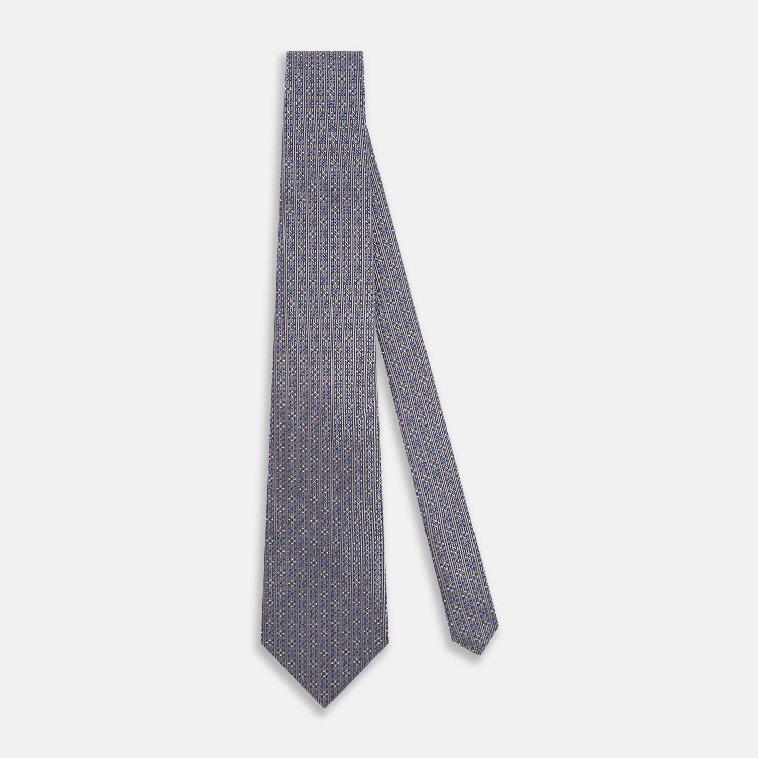 View 2 of product The Turnbull & Asser Silver and Pale Blue Multi Dot Silk Tie features elegant small dots on light brown silk, ideal for modern office wear, shown rolled up against a white background.