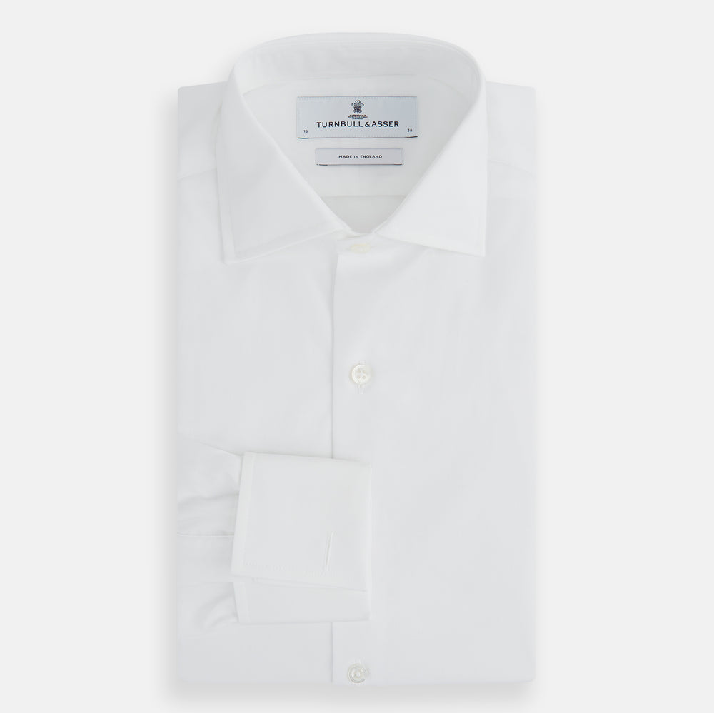 The Turnbull & Asser Tailored Fit Plain White Cotton Shirt features a Kent collar, button-down front, long sleeves, and double cuffs, shown on a white background.