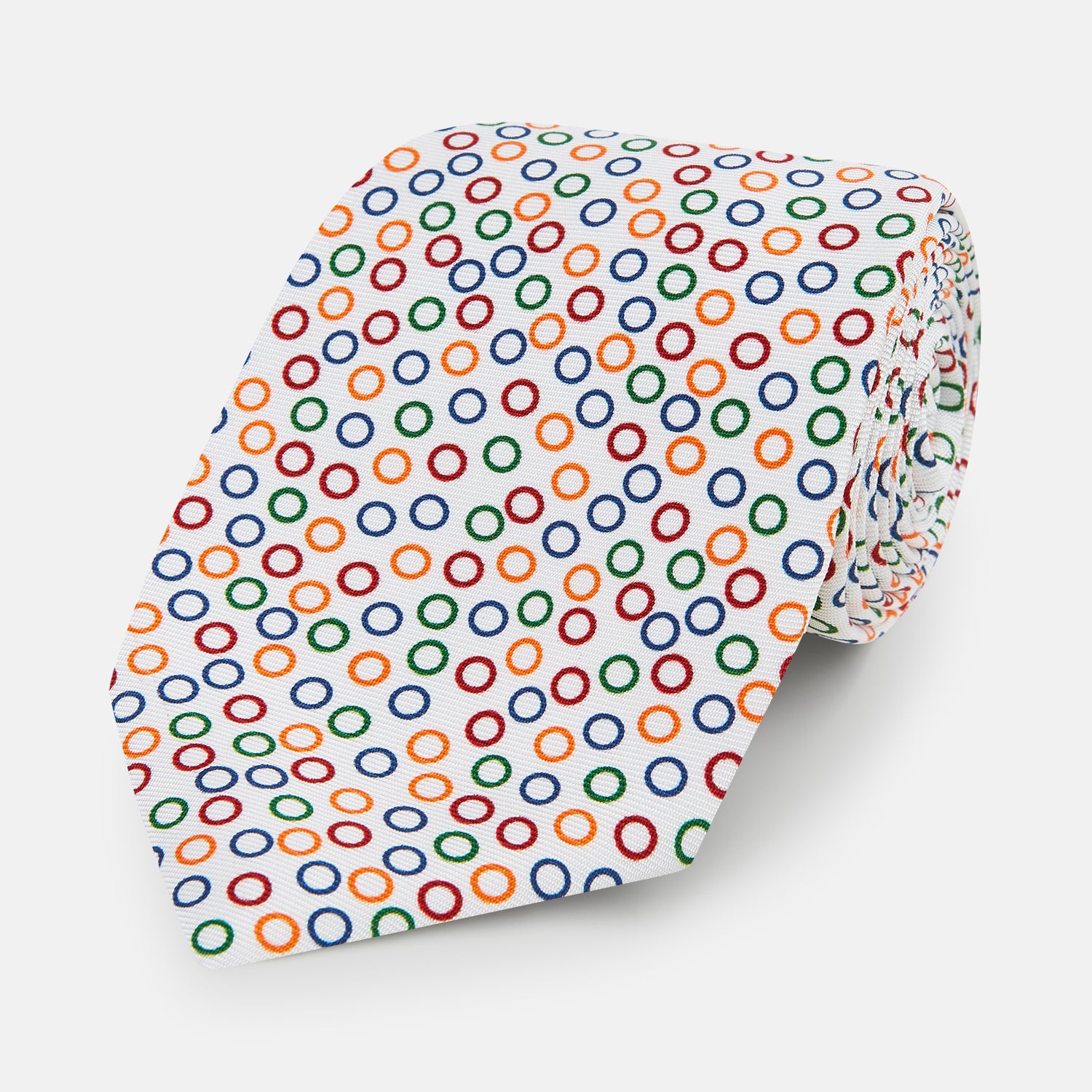 View 1 of product The Turnbull & Asser Confetti Circle White Silk Tie features colorful rings in red, orange, blue, and green scattered across a crisp white background.