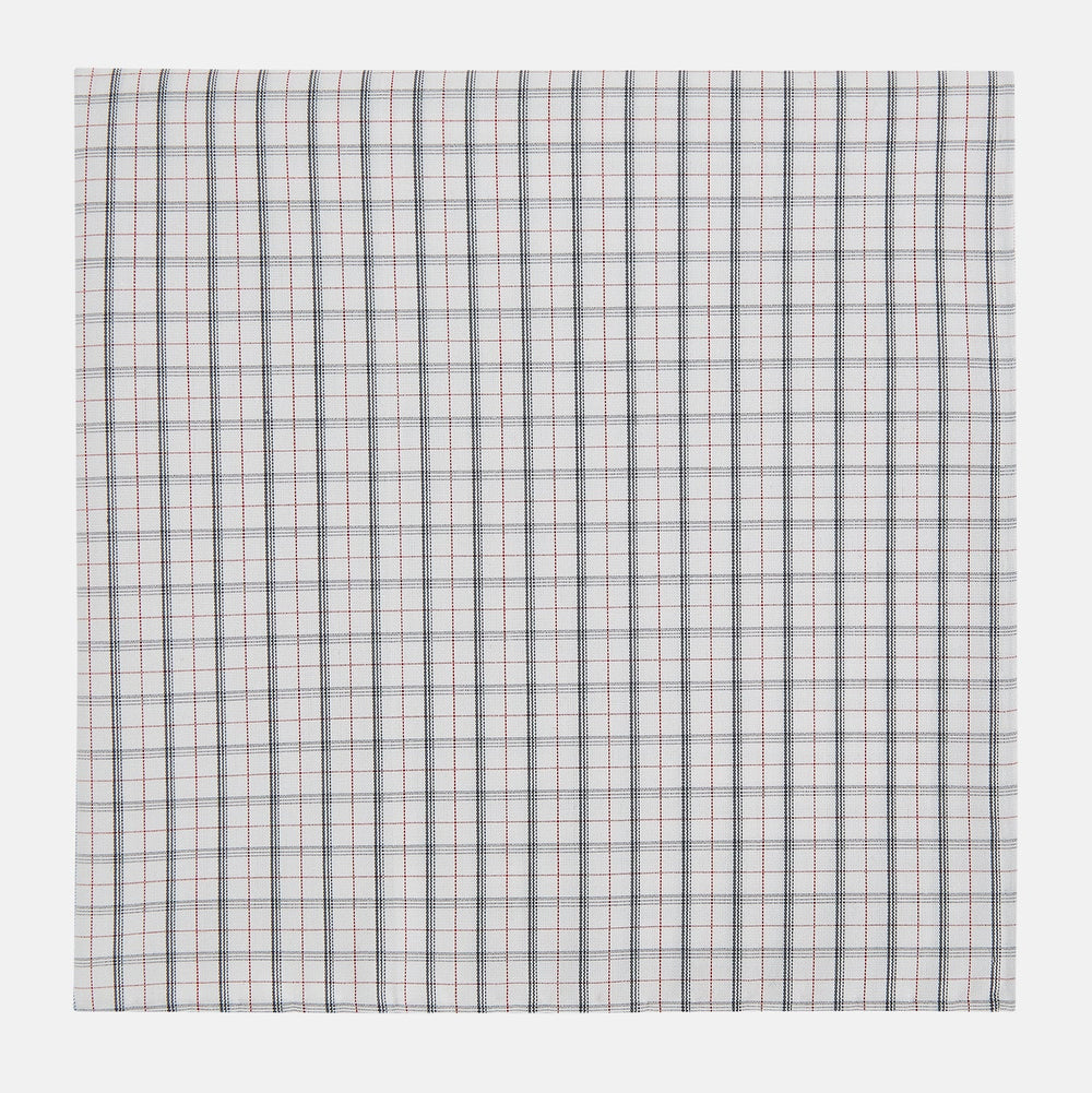 The Red Multi Graph Check Hand-Rolled Handkerchief by Turnbull & Asser features thin black, red, and blue lines forming small squares on white fabric, finished with delicate hand-rolled edges.