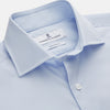 View 2 of product The Turnbull & Asser Tailored Fit Light Blue Cotton Shirt features a Kent collar and 3-button cuffs, perfect for pairing with a navy suit or smart ensemble. Laid flat on a white background.