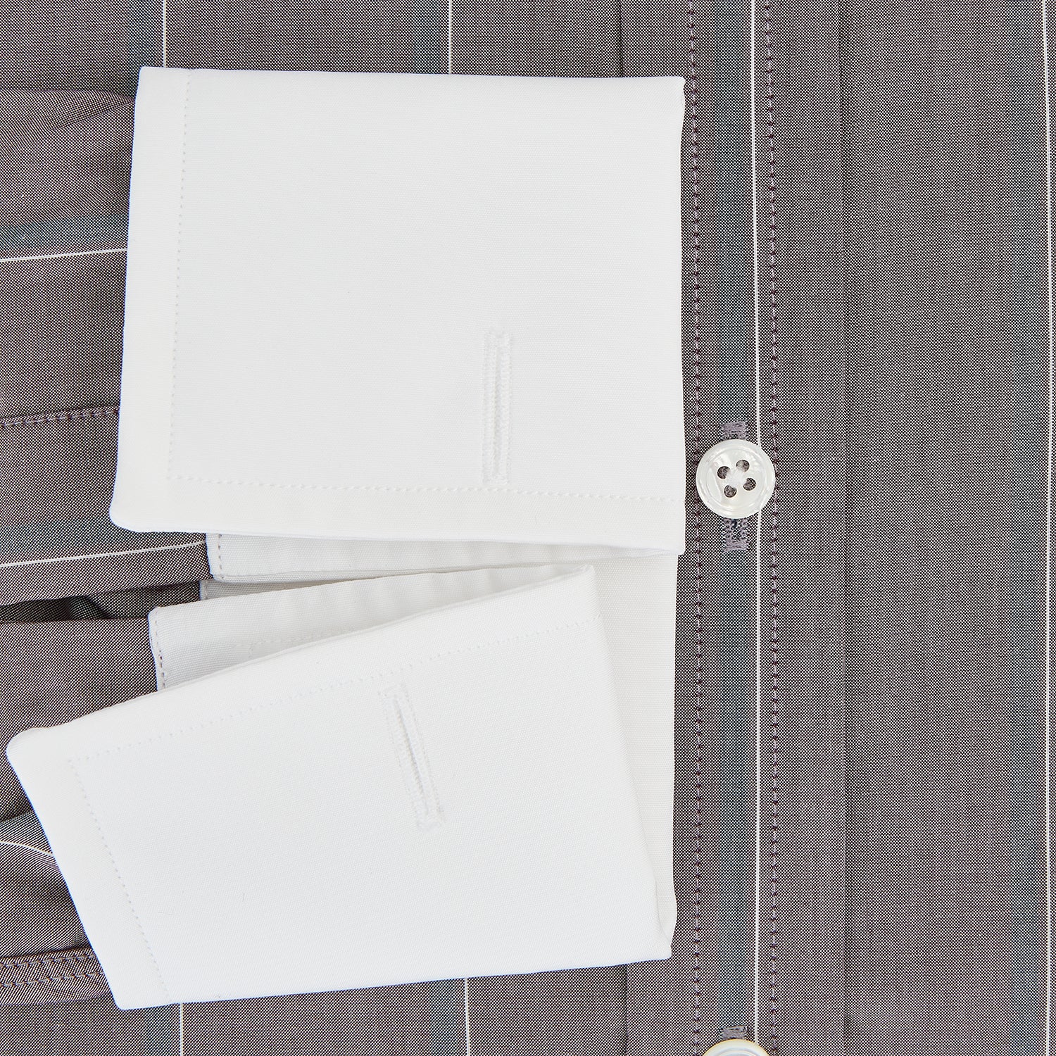 View 4 of product The Turnbull & Asser Light Porto Red Track Stripe Shirt features a Mayfair fit and contrast white T&A collar and cuffs, with vertical blue stripes on mauve, exemplifying British craftsmanship.