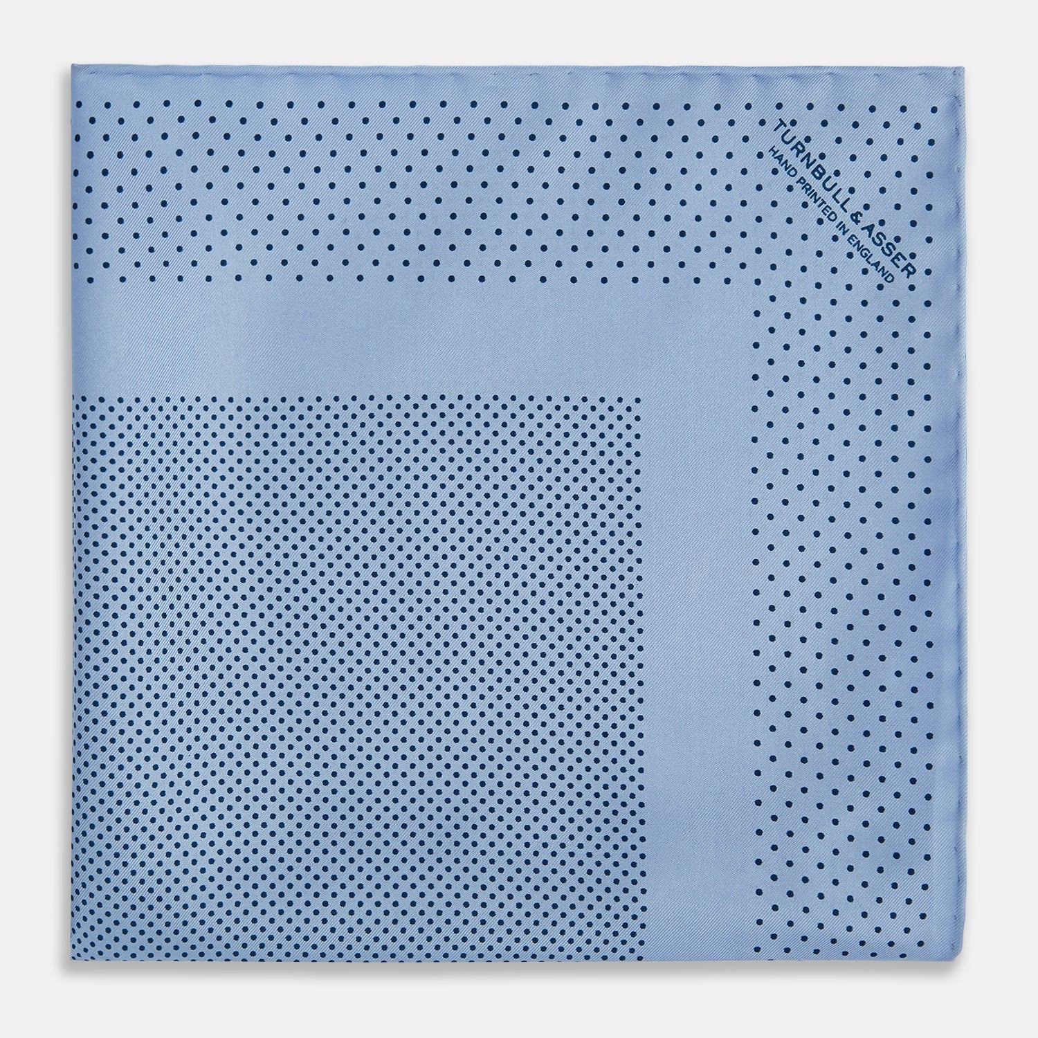 View 3 of product The Turnbull & Asser Pale Blue Dot Silk Pocket Square features pure silk in pale blue with a border and scattered small navy polka dots, neatly folded with one corner turned down.