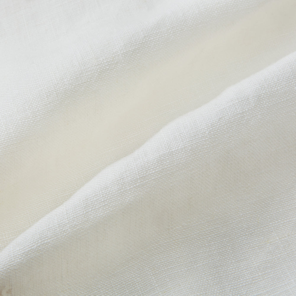 The Vanilla Linen Holland Shacket by Turnbull & Asser, a white Irish linen button-up with a collar, brown buttons, and four pockets, is laid flat on a white background—perfect as lightweight outerwear.