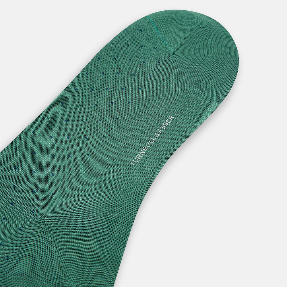 The Turnbull & Asser Forest Green/Navy Dot Mid-Length Sock is shown upright with the foot pointed right against a white background, highlighting its subtle polka dot pattern.