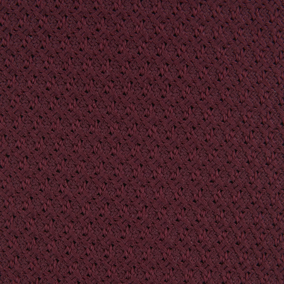 View 3 of product The Turnbull & Asser Plain Woven Grenadine Silk Tie, shown rolled at one end on a white background, features a rich burgundy hue and textured pattern—an essential accessory for sophisticated looks.