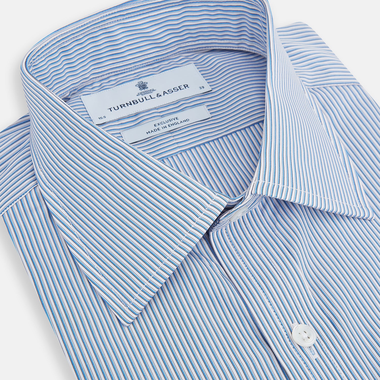 View 2 of product The Turnbull & Asser Pale Blue Pinstripe Mayfair Shirt features pale blue pinstripes, a classic T&A collar, white buttons, and cuffed sleeves, shown against a plain white background.