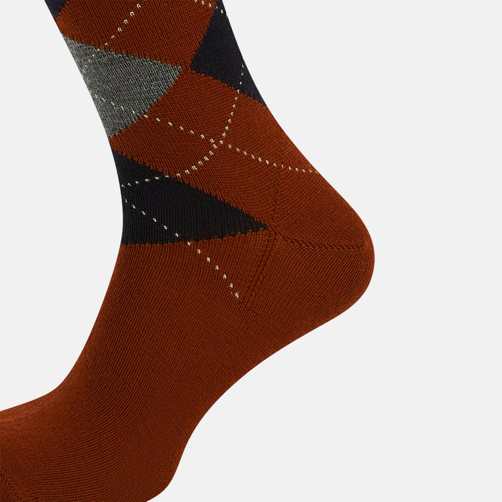 The Turnbull & Asser Rust Wool Check Mid-Length Sock features a brown wool design with black, gray, and orange checks, shown on a white background.