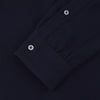 View 2 of product The Turnbull & Asser Navy Cashmere Cotton Shirt is a formal, dark navy blue shirt with a collar and front pocket, crafted from a luxurious cotton and cashmere blend, shown neatly folded against a white background.