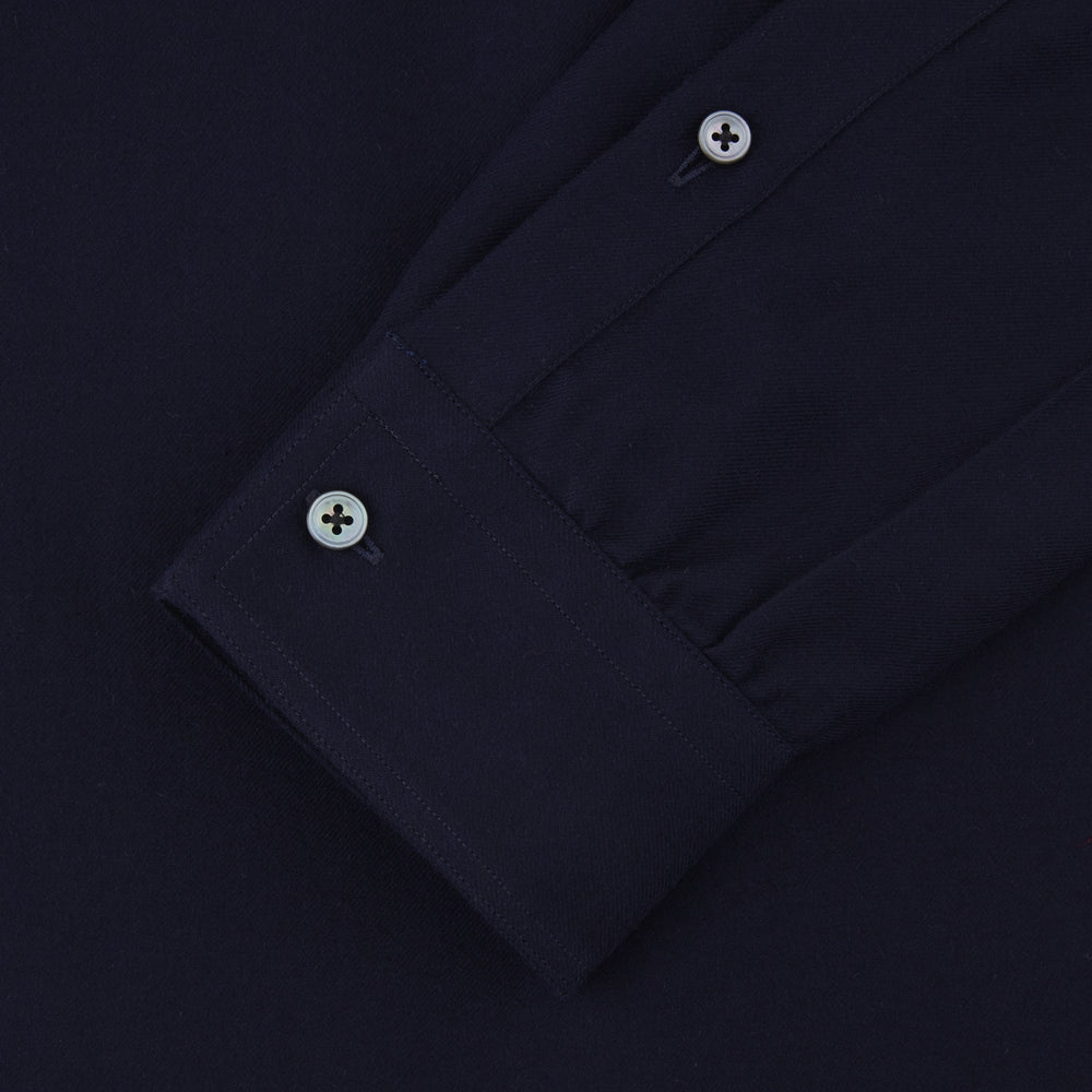 The Turnbull & Asser Navy Cashmere Cotton Shirt is a formal, dark navy blue shirt with a collar and front pocket, crafted from a luxurious cotton and cashmere blend, shown neatly folded against a white background.
