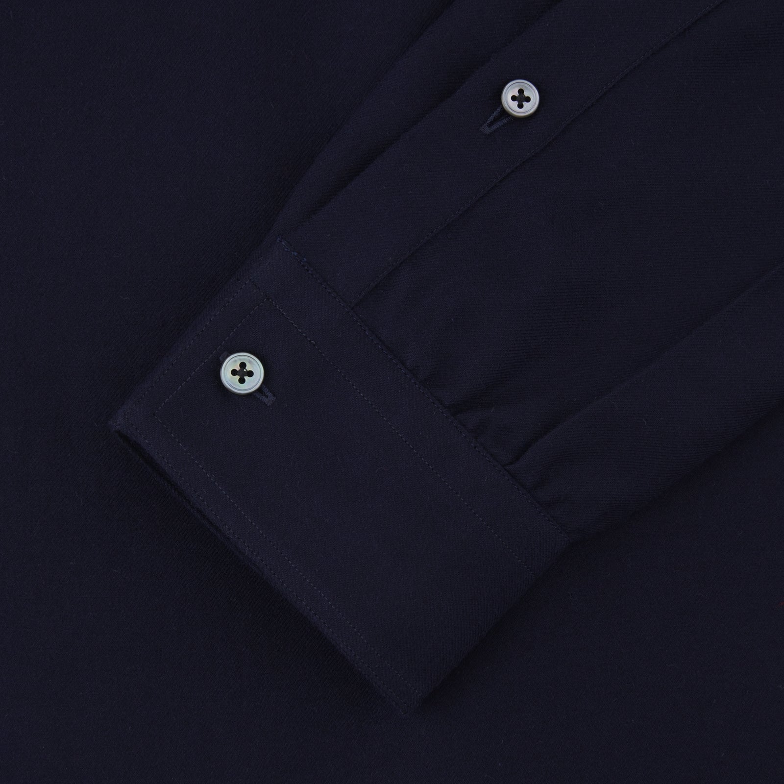 View 2 of product The Turnbull & Asser Navy Cashmere Cotton Shirt is a formal, dark navy blue shirt with a collar and front pocket, crafted from a luxurious cotton and cashmere blend, shown neatly folded against a white background.