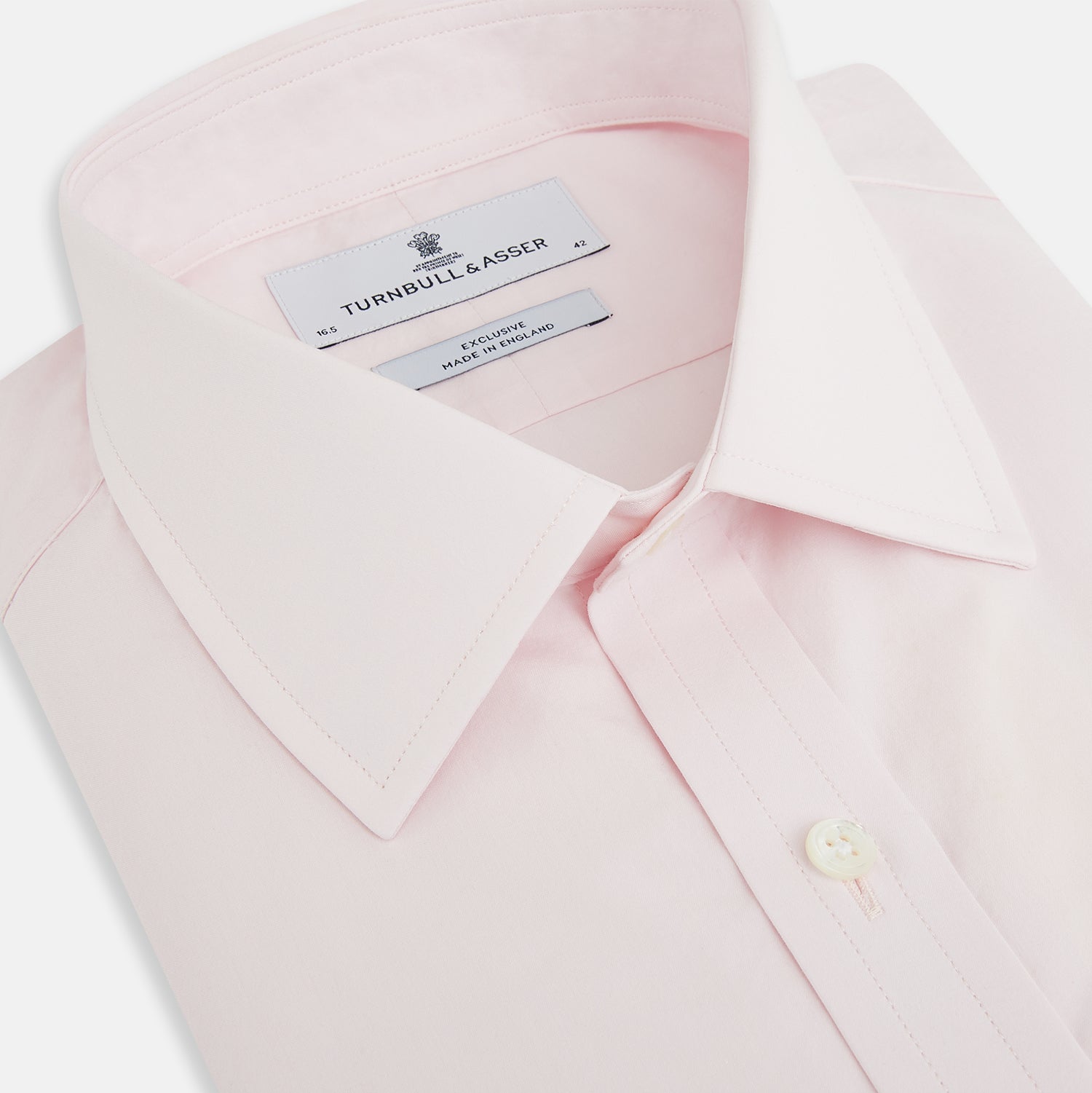 View 2 of product The Soft Pink Mayfair Shirt by Turnbull & Asser is a long-sleeved, sanforised cotton button-up with a classic collar, white buttons, and buttoned cuffs, shown against a plain white background.