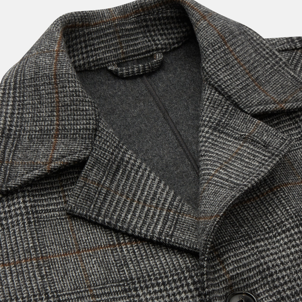 The Turnbull & Asser Grey Multi Check Wool Bernard Car Coat features a collar, three front buttons, long sleeves, and knee-length Prince of Wales check wool, shown against a white background.