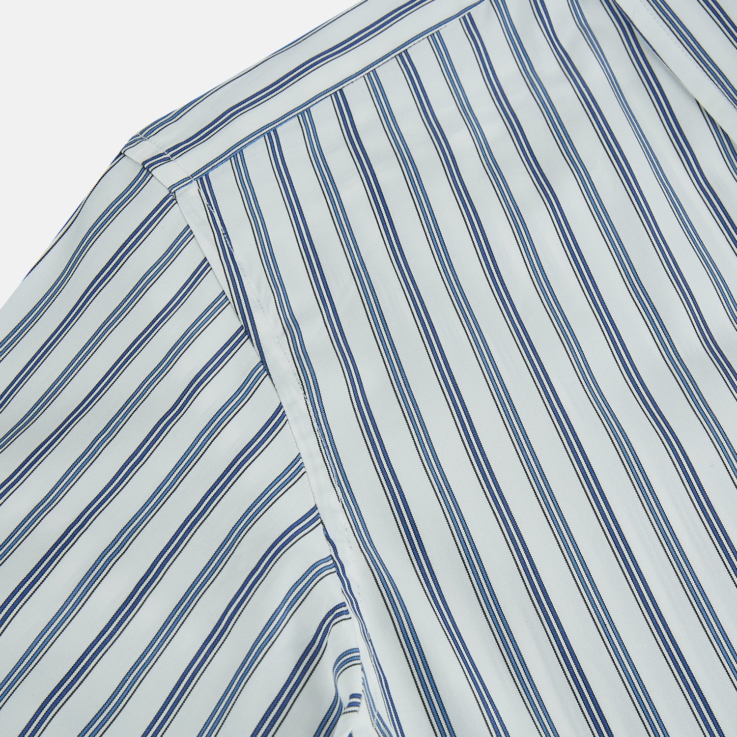 View 6 of product The SAPPHIRE BLUE MULTI TRACK STRIPE WINDSOR SHIRT by Turnbull & Asser features long sleeves, button-up front, classic collar, blue and white vertical stripes, buttoned cuffs, and showcases British craftsmanship on a white background.