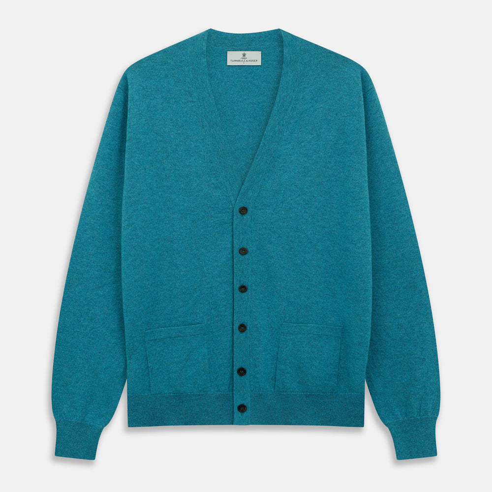 The Teal Lachlan Cashmere Cardigan by Turnbull & Asser features long sleeves, front pockets, and ribbed hem and cuffs. Displayed flat on a white background, this cozy piece is inspired by classic Scottish knitwear.