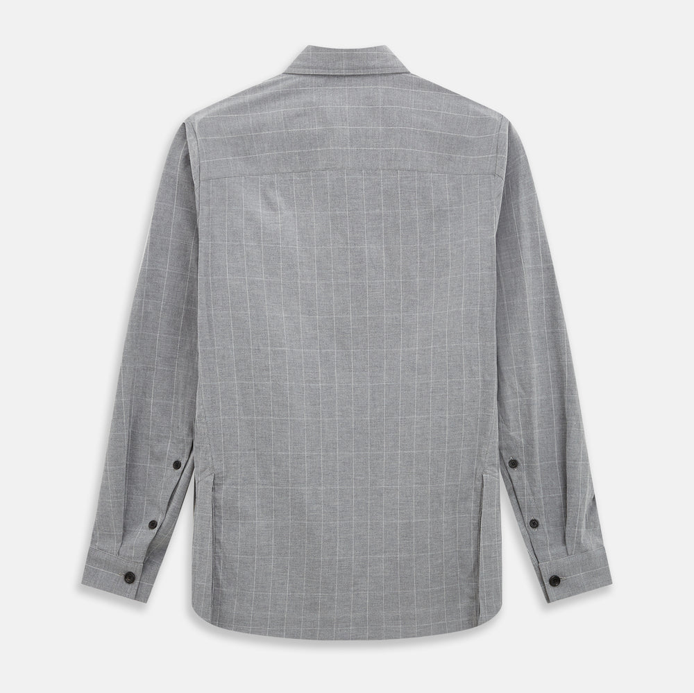 The Turnbull & Asser Grey Check Hampstead Overshirt features a light gray check pattern, pointed collar, chest pocket, and two zippered side pockets, displayed flat against a white background.