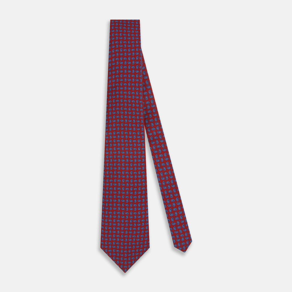 The Turnbull & Asser Red and Purple Miniature Paisley Silk Tie is neatly rolled with the pointed end facing forward.