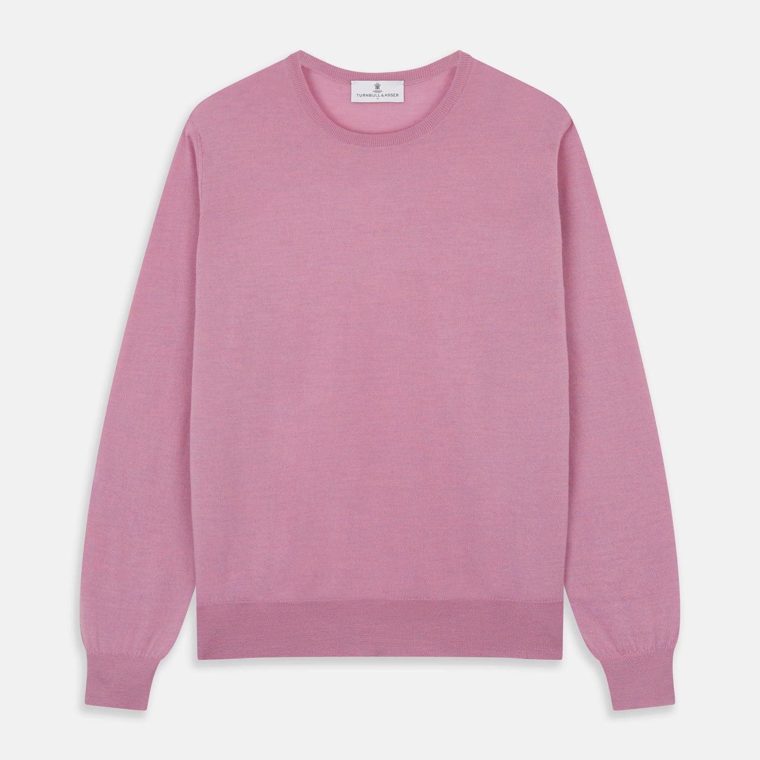 View 2 of product Wearing Turnbull & Asser’s Pink Merino Kingston Crew Neck Jumper, white pants, and a colorful scarf, a person stands against a plain light gray background with hands in their pockets.