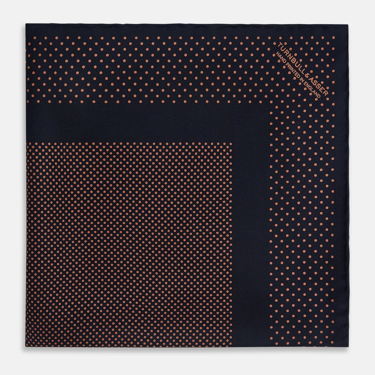 View 4 of product The Navy and Blush Dot Silk Pocket Square by Turnbull & Asser features a navy base with small orange polka dots and a border, shown neatly folded with one corner flipped over.