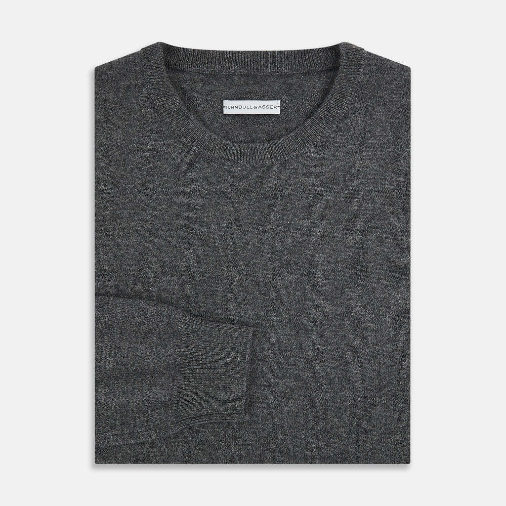 The Turnbull & Asser Charcoal Grey Cashmere Round Neck Jumper features a crew neck, long sleeves, and ribbed cuffs, collar, and hem—an essential piece of men’s knitwear displayed on a white background.