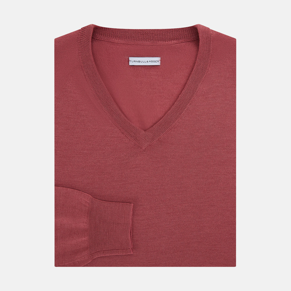 The Turnbull & Asser Antique Pink Merino V-Neck Jumper features ribbed cuffs, hem, and neckline in a soft antique pink, shown on a plain white background. Part of our knitwear collection.