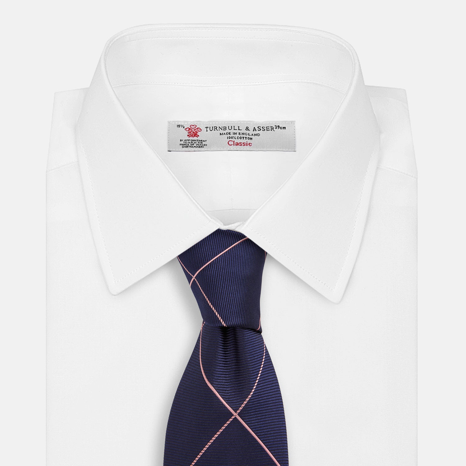 View 2 of product The Turnbull & Asser FONDANT PINK and WINDOW PANE NAVY Silk Tie features a subtle ribbed texture with a pink grid pattern on navy—an elegant choice for polished office attire, shown neatly rolled on a white background.