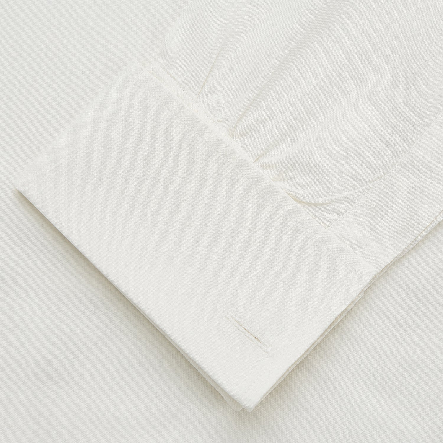 View 4 of product The Turnbull & Asser Cream Silk Weekend Fit Fairlight Shirt is a classic, soft-touch long-sleeve shirt with a collar, button-down front, and buttoned cuffs, shown laid flat on a plain white background.