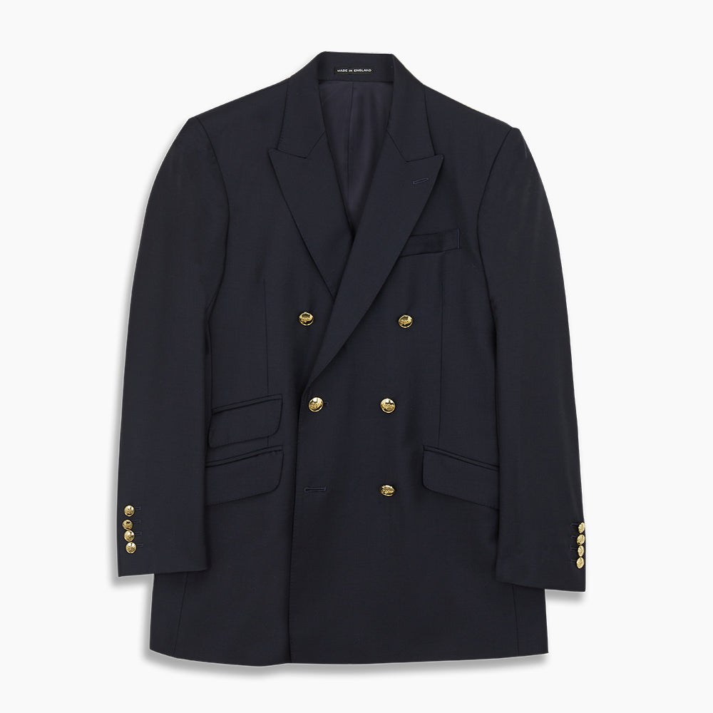 The Classic Navy Wool Blazer by Turnbull & Asser is a nautical double-breasted jacket with gold buttons, peaked lapels, three front pockets on one side, one on the other, and four gold buttons per cuff, shown against a white background.