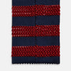 View 4 of product The Turnbull & Asser KNITTED STRIPE RED TIE features bold red and navy wide stripes in a rolled-up, knitted design—an eye-catching accessory shown on a plain white background.