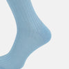 View 4 of product A single Turnbull & Asser Pale Blue Mid-Length Sock, made from Egyptian cotton with a ribbed texture, is displayed upright against a plain white background.
