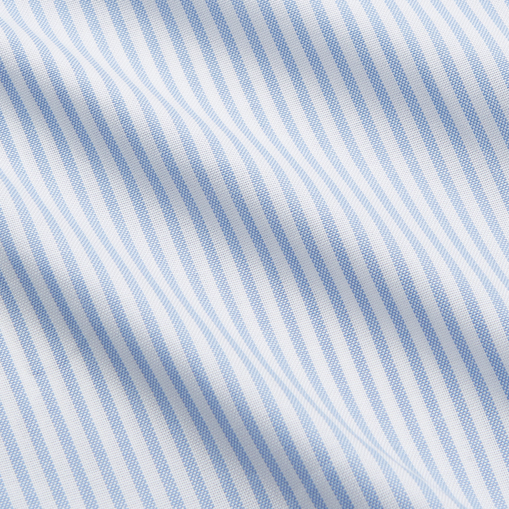 The Turnbull & Asser Pale Blue Stripe Weekend Fit Hayne Shirt features a Dorset collar, 1-button cuffs, and vertical stripes, shown laid flat against a white background.