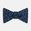 View 1 of product The Turnbull & Asser Multicoloured Dark Navy Circle Silk Bow Tie showcases evenly spaced blue, green, and white ovals—a sophisticated men's accessory perfect for any occasion.