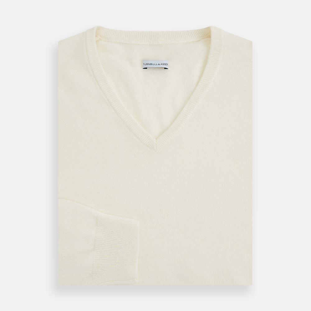 The Turnbull & Asser Ivory Cashmere V-neck Jumper features long sleeves with ribbed cuffs and hem, showcasing timeless knitwear style against a white background.