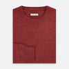 View 4 of product The Turnbull & Asser Crimson Red Cashmere Round Neck Jumper is a classic men’s knitwear piece, featuring long sleeves and a solid crimson hue, shown against a white background.