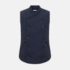 View 1 of product The Turnbull & Asser Navy Double-Breasted Quilted Gilet is a sleeveless piece with an asymmetrical button closure, chest pocket, and two zippered side pockets, shown on a plain white background—ideal for layered dressing.