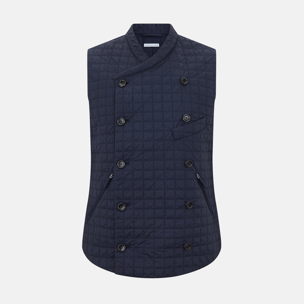 The Turnbull & Asser Navy Double-Breasted Quilted Gilet is a sleeveless piece with an asymmetrical button closure, chest pocket, and two zippered side pockets, shown on a plain white background—ideal for layered dressing.