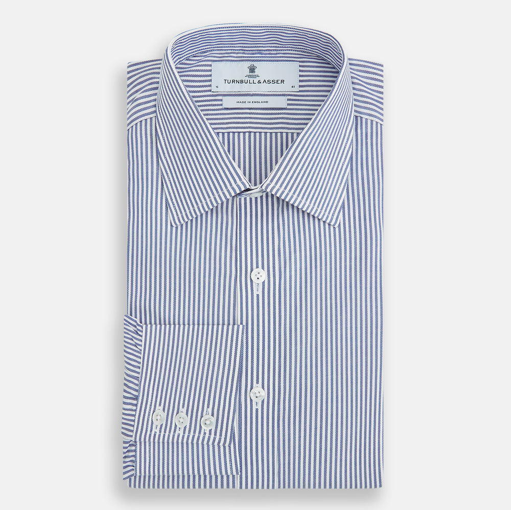 The Turnbull & Asser Navy Bengal Stripe Mayfair Shirt is a long-sleeved, collared formal shirt with blue and white stripes, white buttons, and buttoned cuffs—ideal for classic style enthusiasts. Displayed on a plain white background.