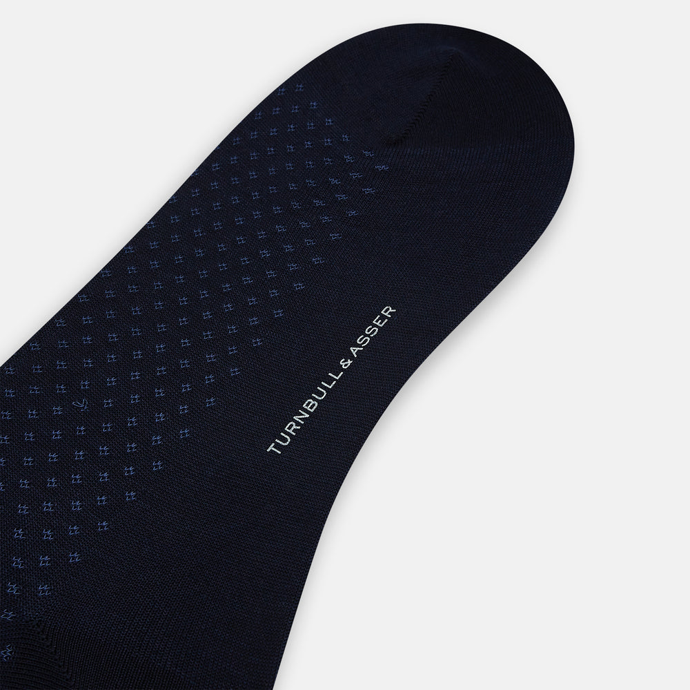 The Turnbull & Asser Midnight Motif Mid-Length Sock is a single black knee-high made from mercerised Egyptian cotton, featuring a subtle dotted pattern, showcased on a plain white background.