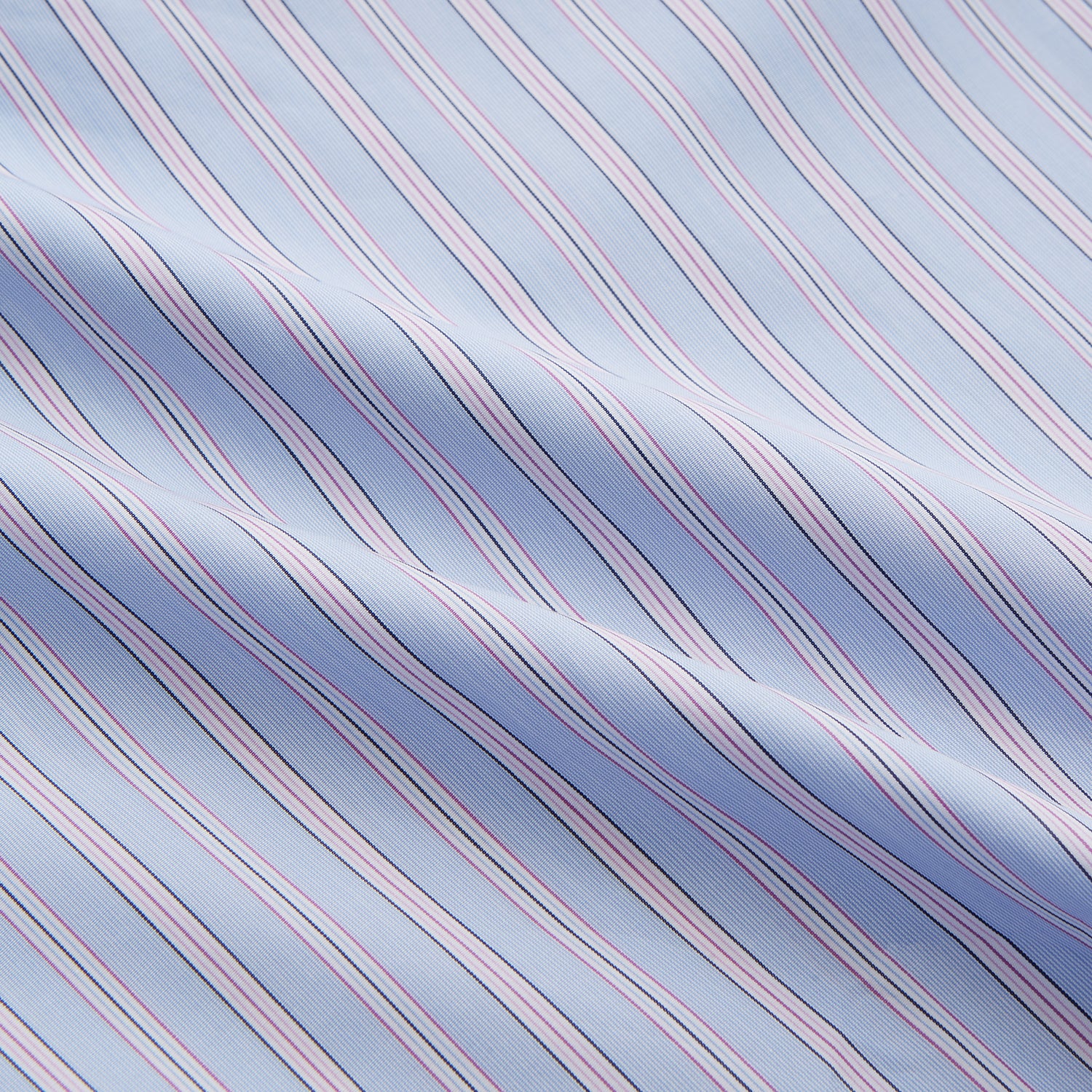 View 4 of product The Blue and Pink Stripe Poplin Cotton Nightshirt by Turnbull & Asser features long sleeves, a collar, front buttons, chest pocket, rounded hem, and light blue fabric with white, pink, and yellow vertical stripes.