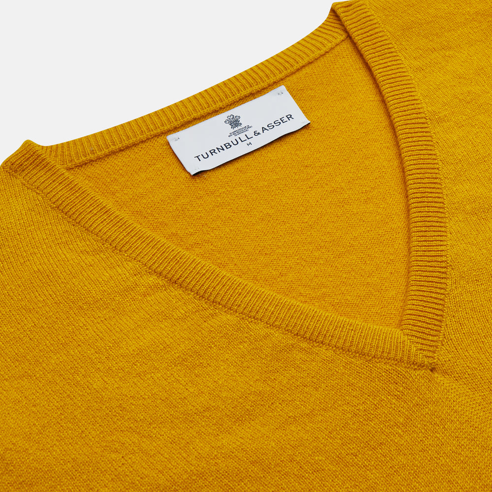 The Gold Ifor Cashmere Slipover by Turnbull & Asser is a sleeveless, V-neck knit in bright mustard yellow, made in Scotland and shown laid flat against a white background.