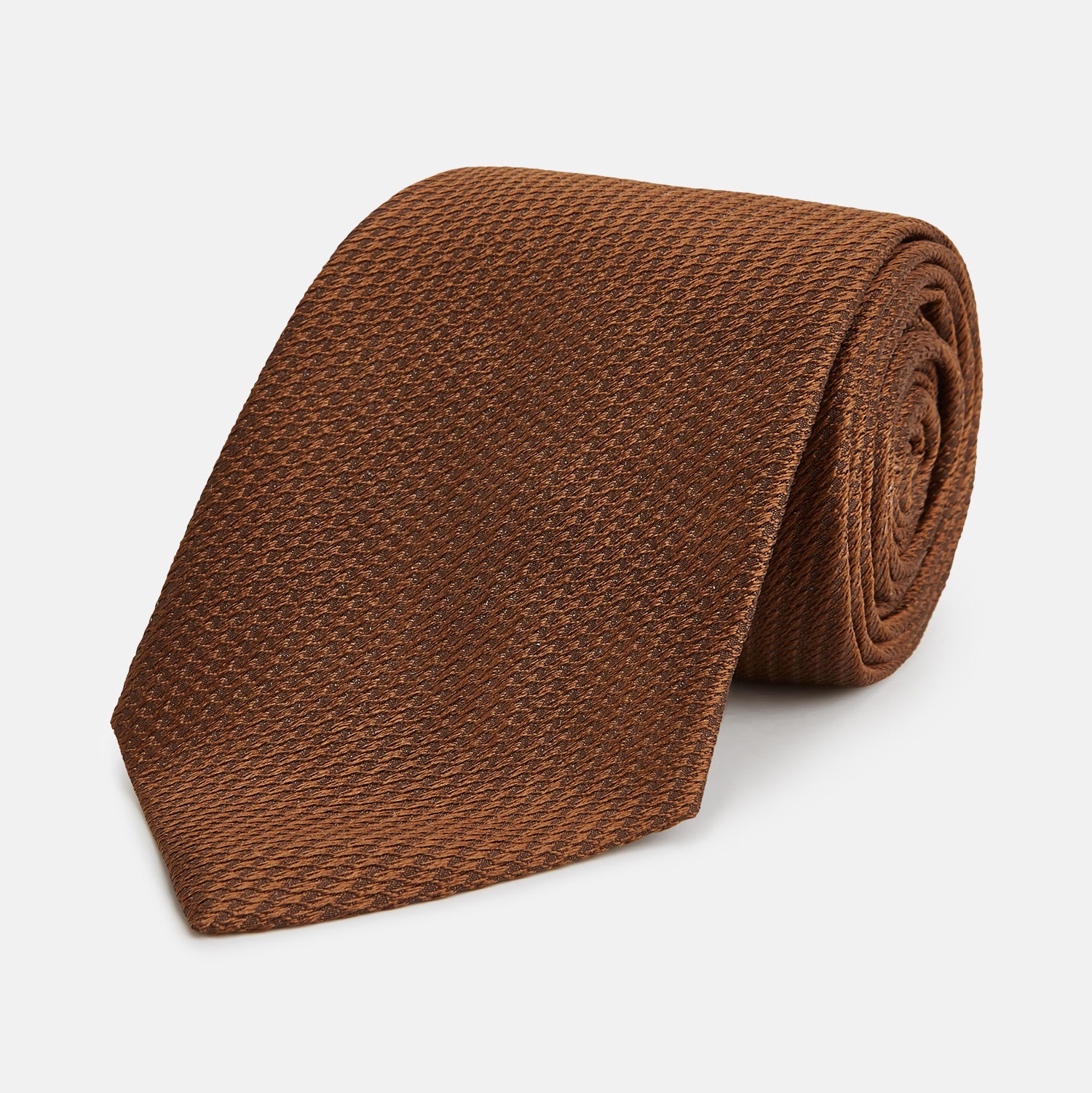 View 1 of product The Turnbull & Asser Plain Lace Jacquard Earth Tie, an essential brown wardrobe accessory, is shown rolled up against a plain white background.