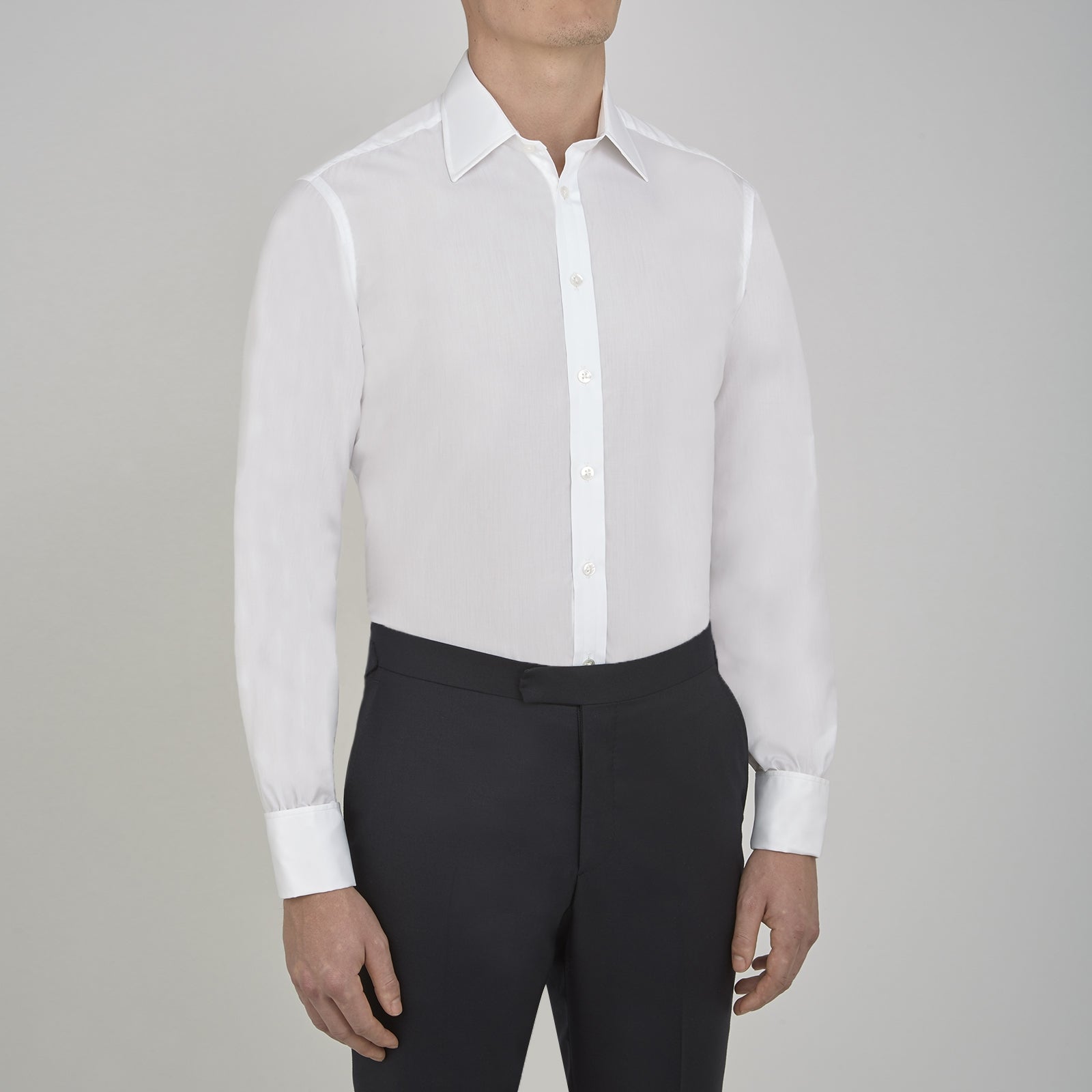 View 2 of product A Turnbull & Asser Two-Fold 200 White Cotton Shirt with T&A collar and double cuffs, neatly folded to show the label inside the collar, is displayed on a light blue background.