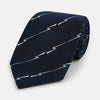 View 1 of product The Turnbull & Asser Navy Zigzag Jacquard Silk Tie is crafted from fine English silk, featuring a navy base with thin white zigzag stripes and shown rolled up on a plain white background.