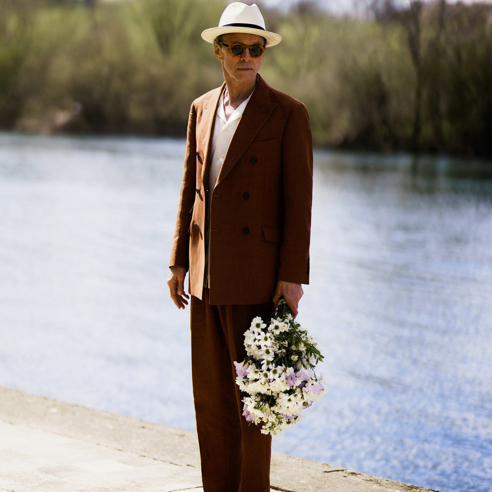 The Turnbull & Asser Rust Linen-Wool-Silk Bertie Blazer is a red double-breasted jacket with peak lapels, black buttons, and flap pockets, tailored in Italy from a luxury linen-wool-silk blend and shown on a white background.