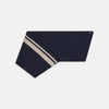 View 3 of product The Navy and Sand Stripe Neck Warmer by Turnbull & Asser features two beige diagonal stripes and a black button, draped in a V shape on a white background—an elegant formal accessory for any occasion.