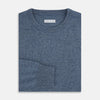 View 4 of product The Turnbull & Asser Pacific Blue Cashmere Round Neck Jumper features long sleeves and ribbed cuffs, hem, and neckline, shown on a light grey background.
