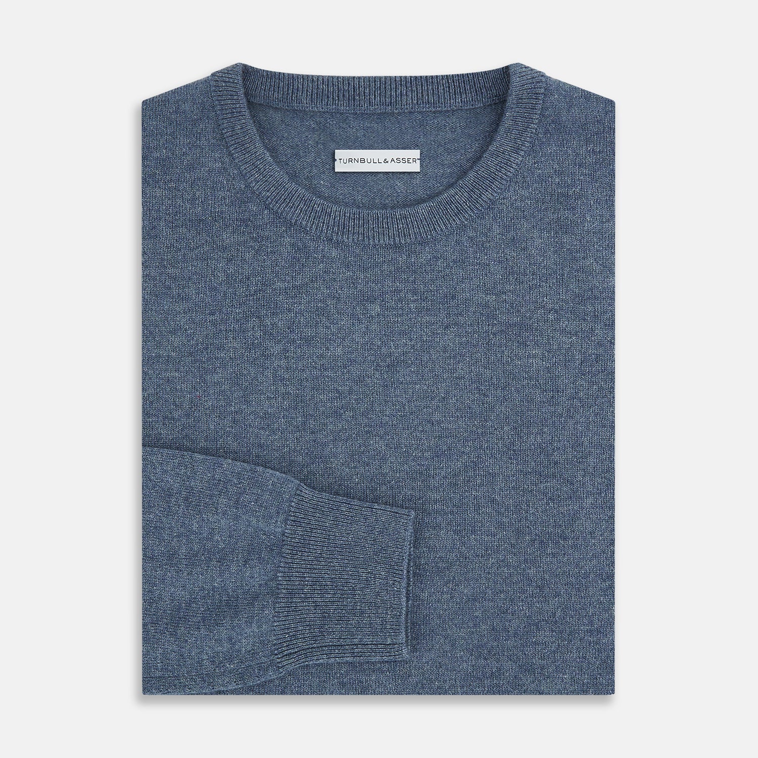 View 4 of product The Turnbull & Asser Pacific Blue Cashmere Round Neck Jumper features long sleeves and ribbed cuffs, hem, and neckline, shown on a light grey background.