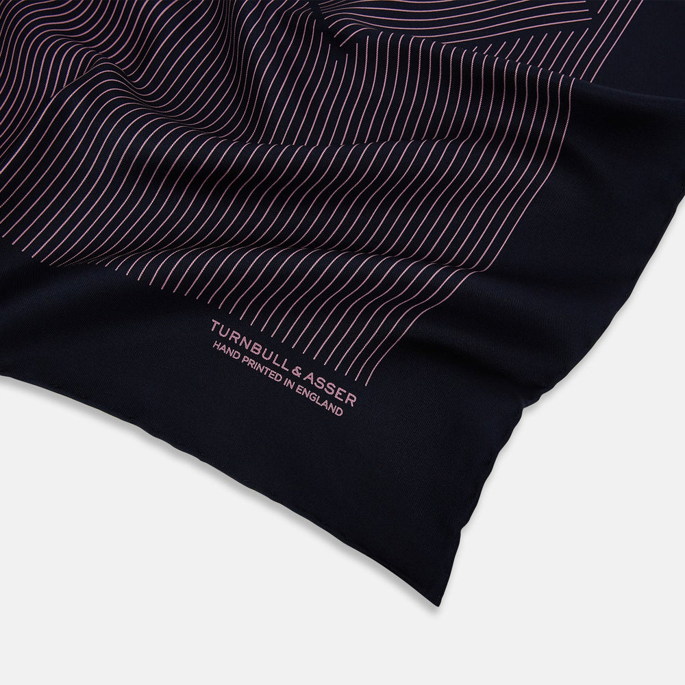 The Navy and Pink Stripe Silk Pocket Square by Turnbull & Asser features thin pink stripes, a geometric border, hand-rolled edges, and "TURNBULL & ASSER HAND PRINTED IN ENGLAND" printed in white.