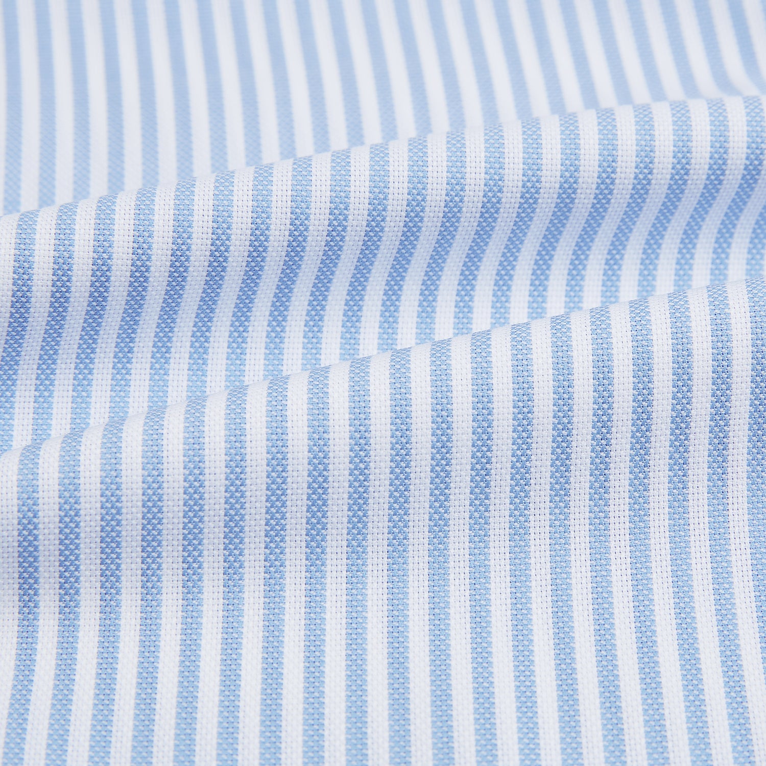 View 6 of product The Turnbull & Asser Blue Bengal Stripe Mayfair Shirt features light blue and white vertical stripes, a classic T&A collar, white buttons, and buttoned cuffs. Laid flat on a white background.